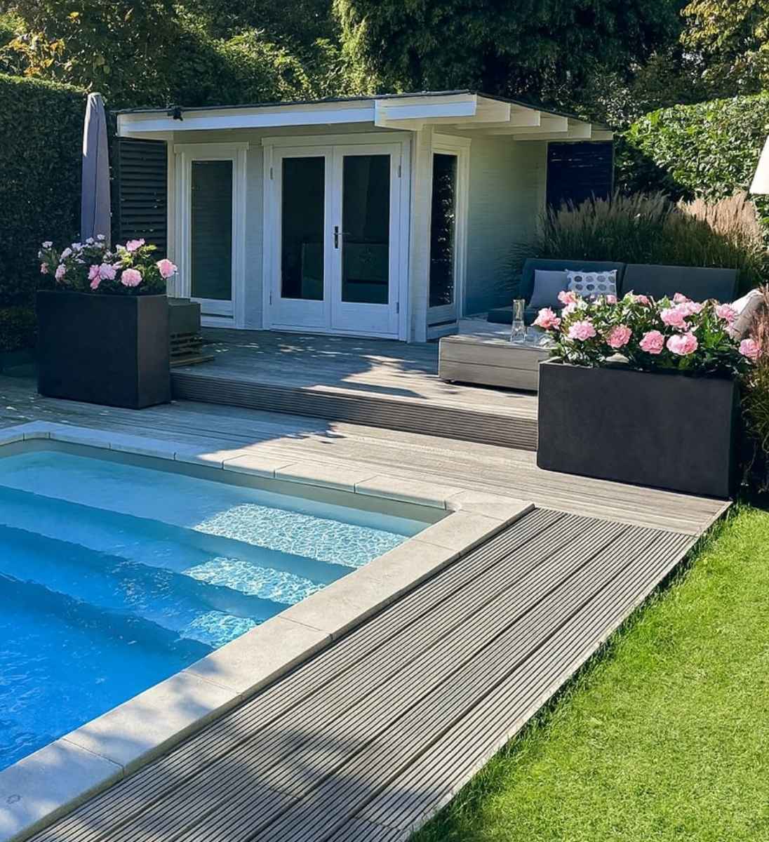 Raumteiler Beton Anthrazit bepflanzt mit Hortensien am Poolbereich im Garten