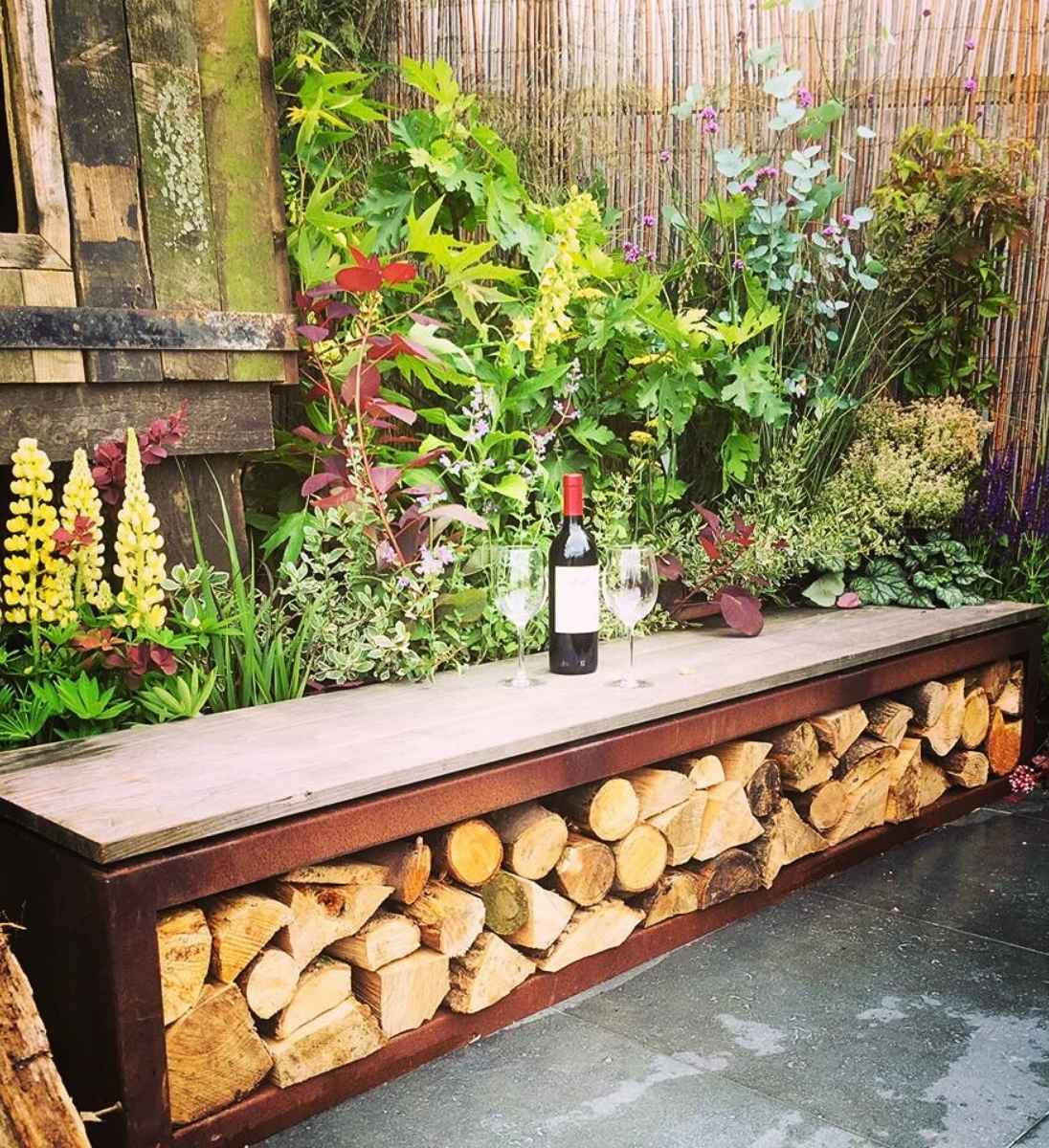 Gartenbank aus Cortenstahl mit integriertem Holzlager von ADEZZ