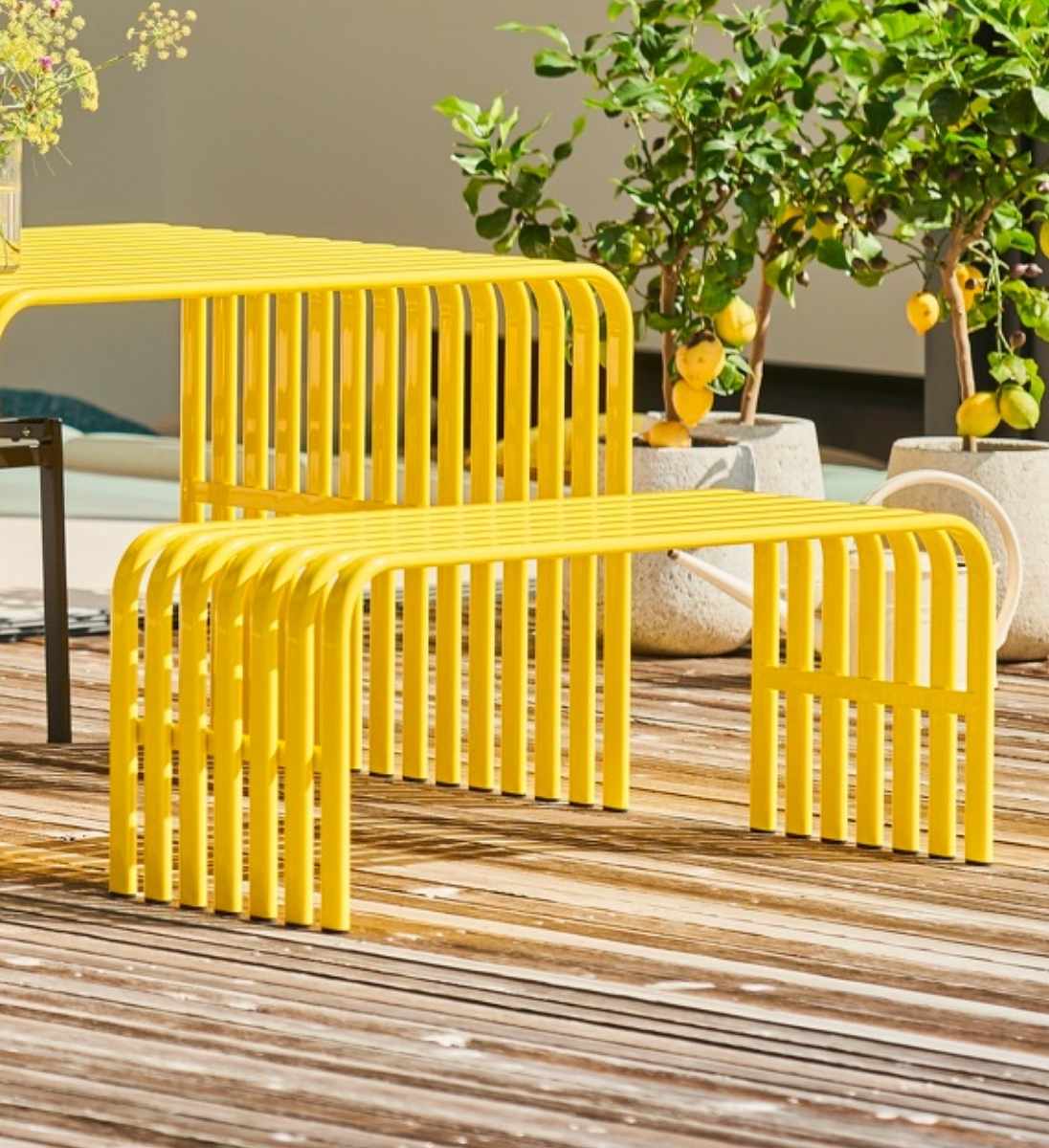 Farbige Gartenbank aus Metall campus von Jan Kurtz kombiniert mit Tisch auf Terrasse