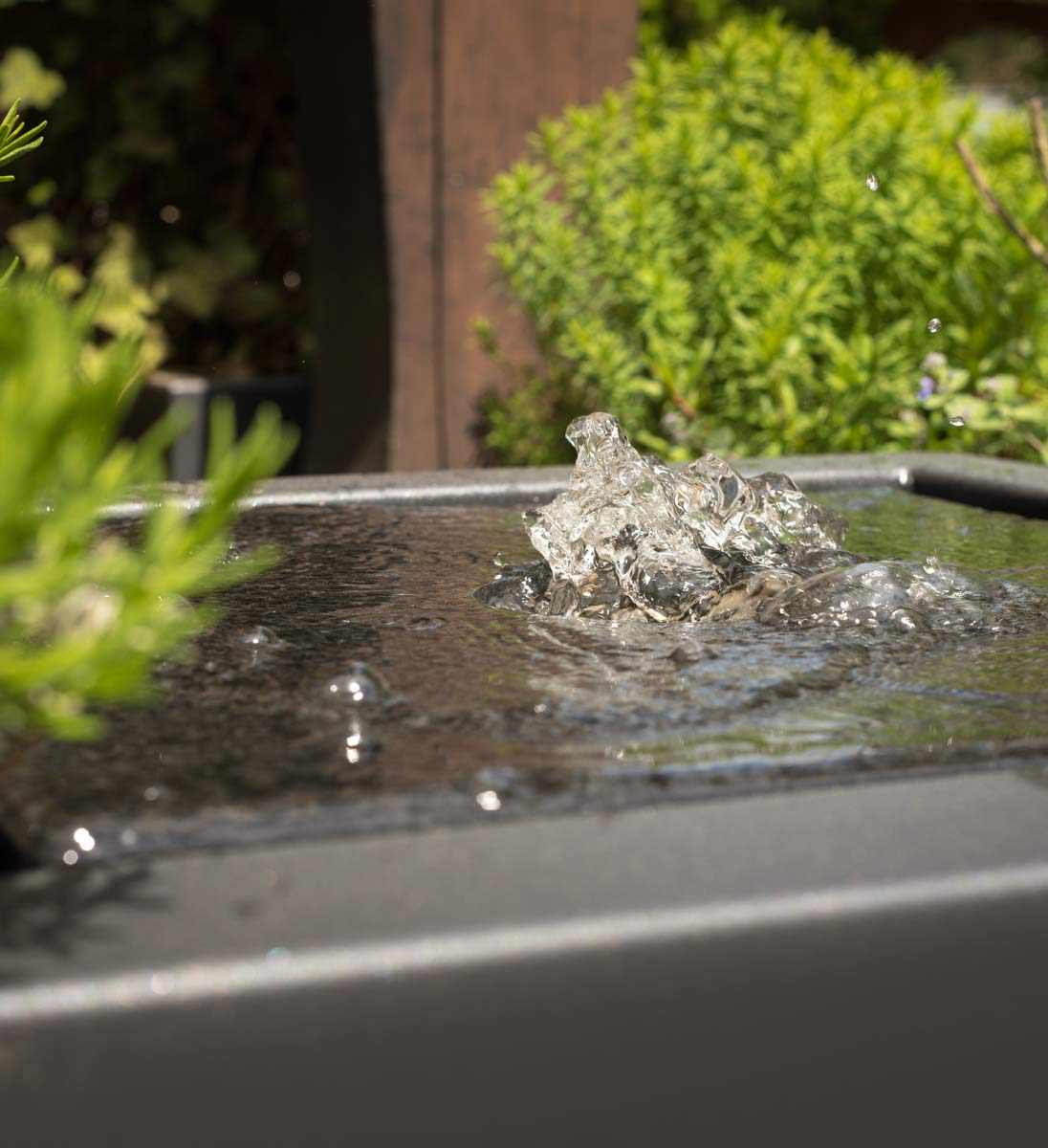 Detailaufnahme Wasserstrudel des Gartensilber Wasserkubus auf Edelstahlplatte