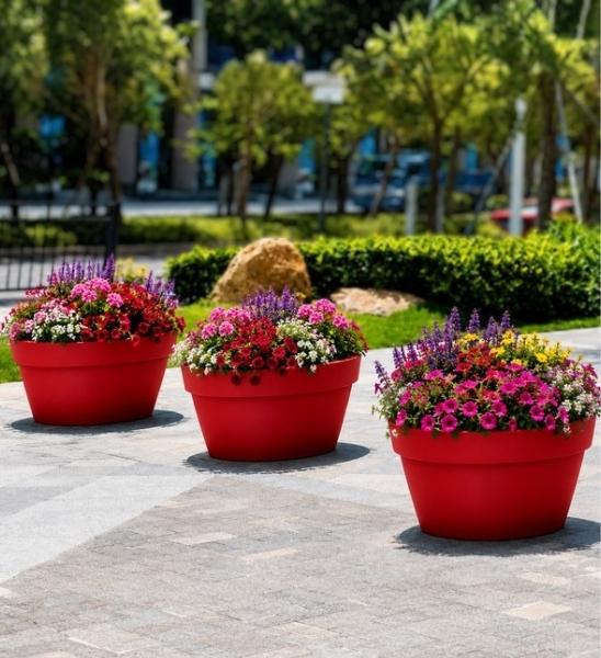 Große Blumenschale aus Kunststoff in Rot auf Gewerbefläche im Außenbereich