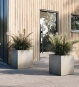Blumenkübel Beton grau ROCCASTONE mit Gräsern bepflanzt auf der Terrasse