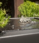 Detailaufnahme Wasserstrudel des Gartensilber Wasserkubus auf Edelstahlplatte