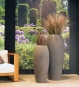 Hohes Pflanzgefäß bauchig betonoptik mit grüner Bepflanzung im Lounge-Bereich