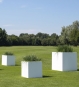 Pflanzkübel Kubus weiß Fiberglas mit Gräsern bepflanzt im Garten
